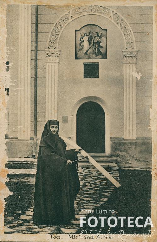 Carte poştală reprezentând o maică care toacă în jurul bisericii mănăstirii Agapia, jud. Neamţ 